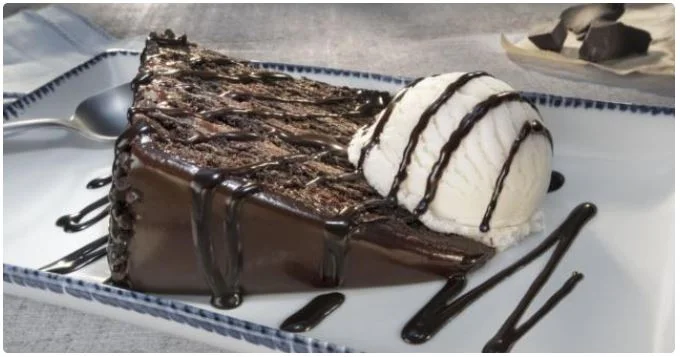 Red Lobster Chocolate Wave — warm, molten-center chocolate cake stacked with silky cocoa frosting, crowned by a melting scoop of vanilla ice cream. $8.99 slice delivers the ultimate cocoa hug, baked to order so every forkful oozes comfort. Gluten-friendly request available; ready in 9 minutes — reserve via app and let the sweet finale hit the table just as your last biscuit disappears. Alt-text (pick 1): Warm Chocolate Wave cake with vanilla ice cream $8.99 Red Lobster dessert